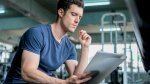 Young-Muscular-Man-Reading-Paper-Notes-In-Gym.jpg