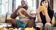 Heavy-Interracial-Couple-Eating-Junk-Food-On-Couch.jpg
