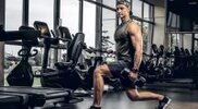 Young-Muscular-Man-Doing-Lunges-In-Dark-Gym